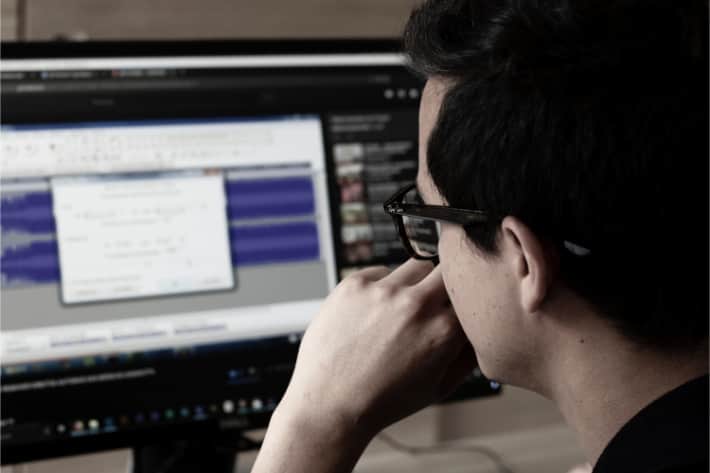 Mann med briller som ser på en dataskjerm med et popup-vindu